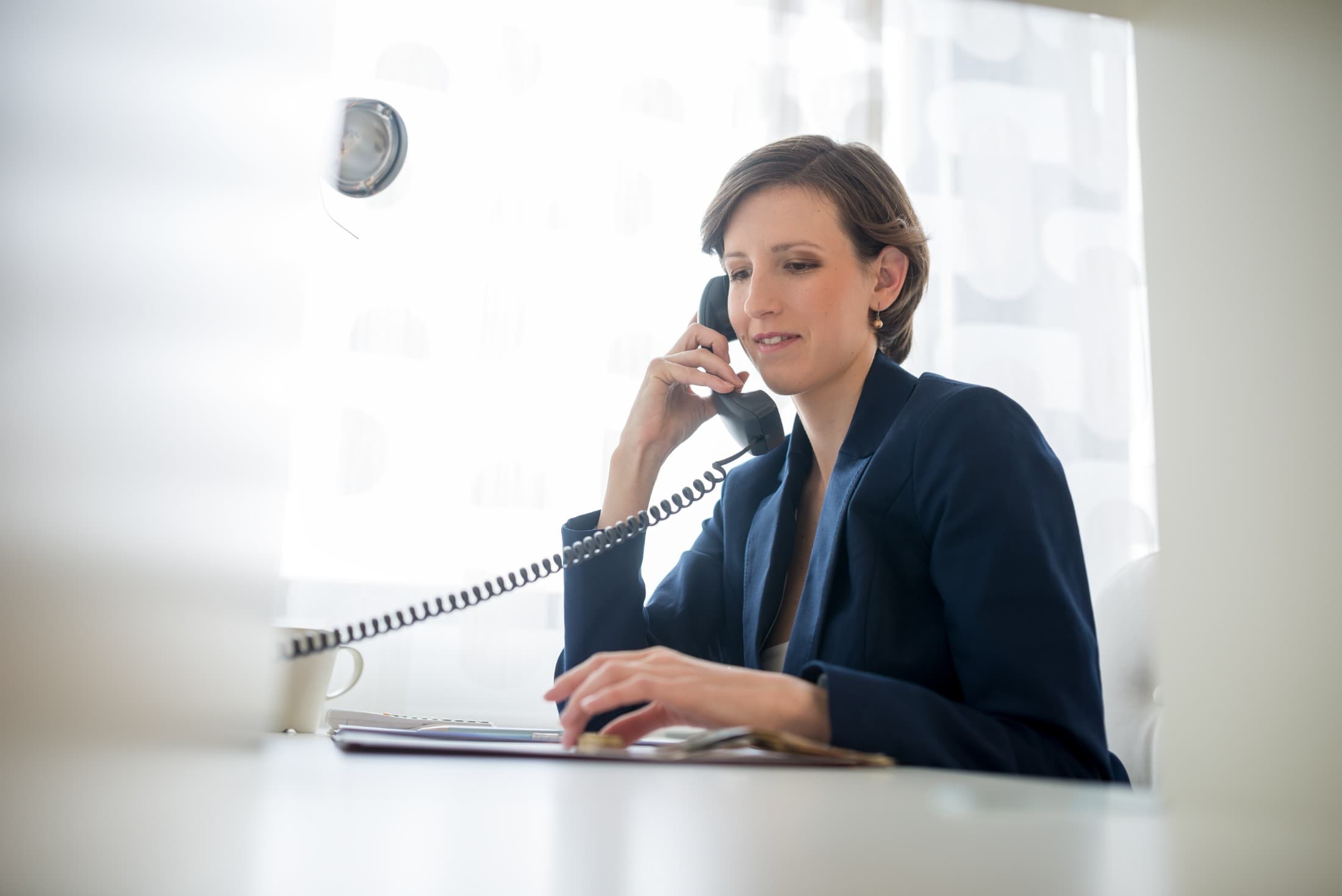 Someone talking on the phone at her desk